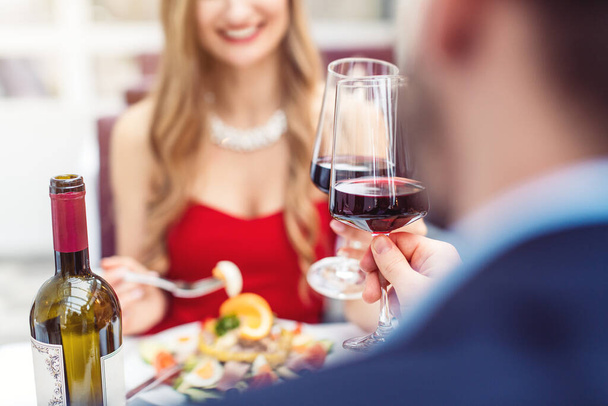 Paar stößt in romantischem Restaurant mit Rotwein an - Foto, Bild