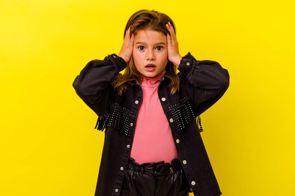 Little caucasian girl isolated on yellow background having fun covering half of face with palm. - Fotoğraf, Görsel