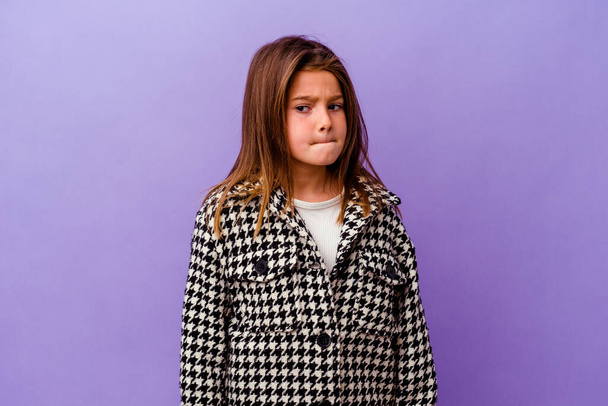 Little caucasian girl isolated on purple background Little caucasian girl isolated on purple background confused, feels doubtful and unsure. - 写真・画像