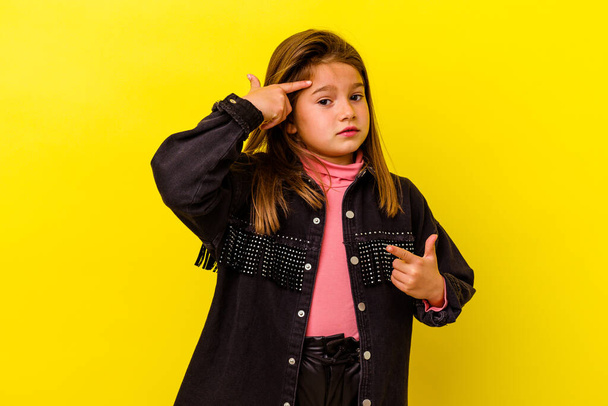 Kis kaukázusi lány elszigetelt sárga háttérrel mutatja csalódottság gesztus mutatva mutatóujj. - Fotó, kép
