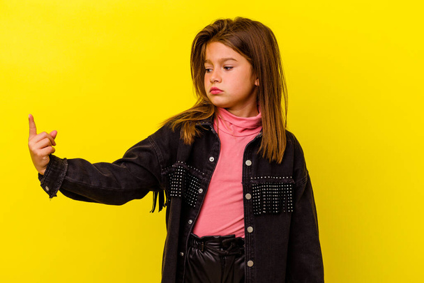 Little caucasian girl isolated on yellow background pointing with finger at you as if inviting come closer. - 写真・画像