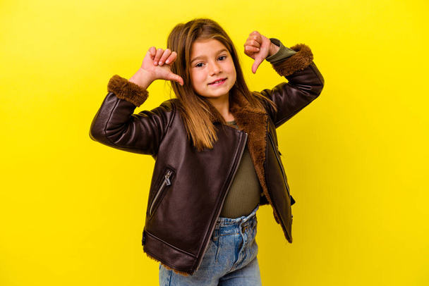 Little caucasian girl isolated on yellow background feels proud and self confident, example to follow. - Photo, Image