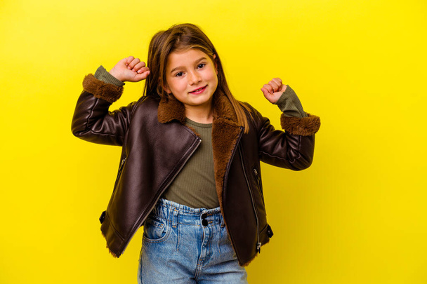 Little caucasian girl isolated on yellow background stretching arms, relaxed position. - 写真・画像