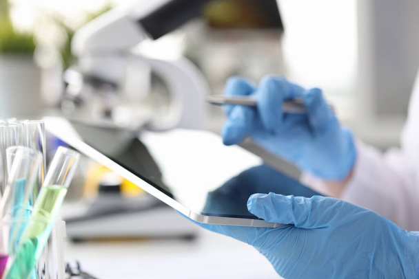 Επιστήμονας χημικός εισάγει τα αποτελέσματα της έρευνας σε ταμπλέτες closeup - Φωτογραφία, εικόνα
