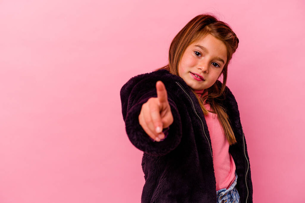 Pequeña chica caucásica aislada sobre fondo rosa mostrando el número uno con el dedo. - Foto, Imagen