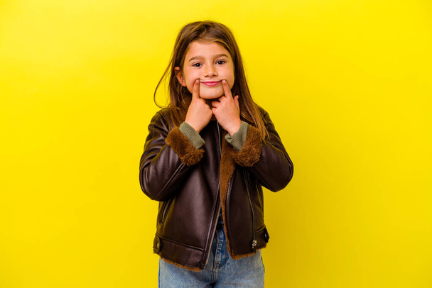 Little caucasian girl isolated on yellow background doubting between two options. - 写真・画像