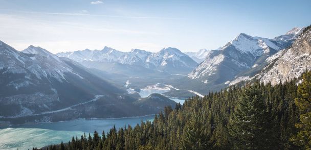 Winter alpine scenery with valley lake and snowy peaks, panoramic shot made in Kananaskis Country, Alberta, Canada - Photo, Image