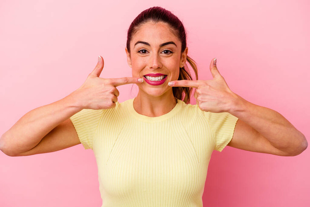 Young caucasian woman isolated on pink background showing victory sign and smiling broadly. - Foto, afbeelding