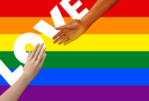 Isolated female hands in reaching to each other gesture with LGBT pride flag and love word. - Photo, Image