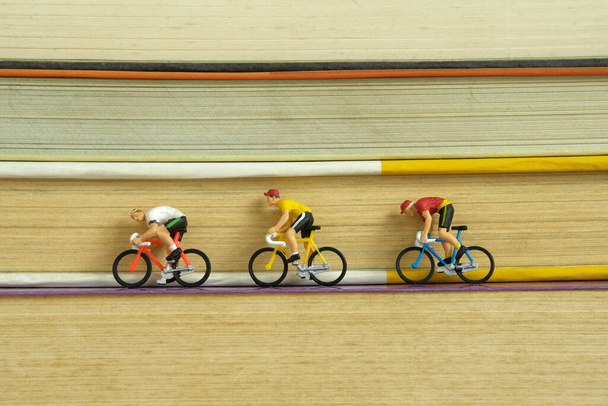 Miniaturmenschen Spielzeugfiguren Fotografie. kreatives Konzept. ein Biker, der über Bücherstapel radelt. Bild-Foto - Foto, Bild