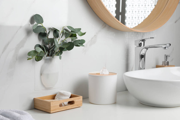 Silicone vase with eucalyptus branches on white marble wall over countertop in stylish bathroom - Fotografie, Obrázek