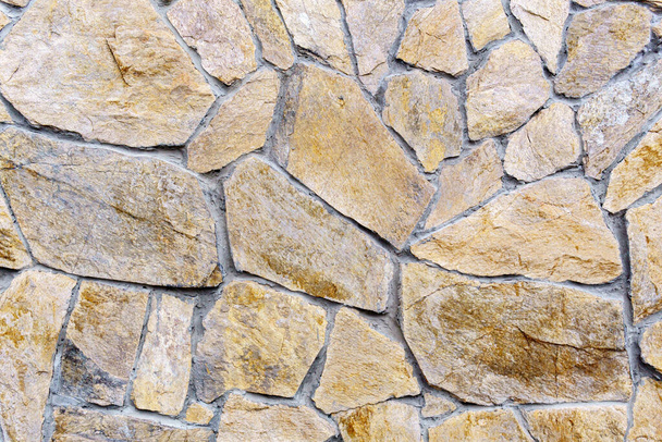 Parete di pietra come sfondo o texture. Parte di un muro di pietra, per uno sfondo o una struttura - Foto, immagini