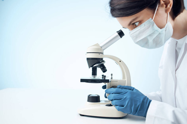 woman laboratory assistant medical mask microscope diagnostics biotechnology - 写真・画像