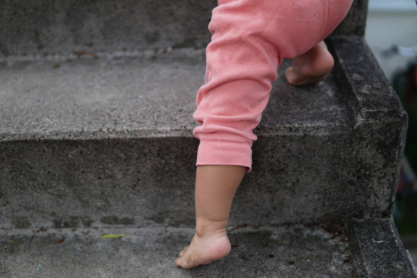 A shot of baby feet climbing stairs - Foto, imagen