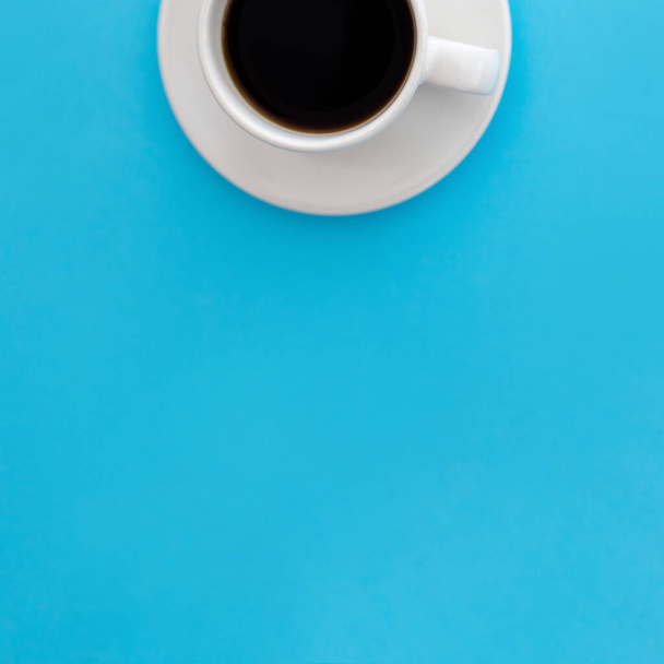 A vertical shot of a mug of coffee isolated on a blue background - Фото, изображение