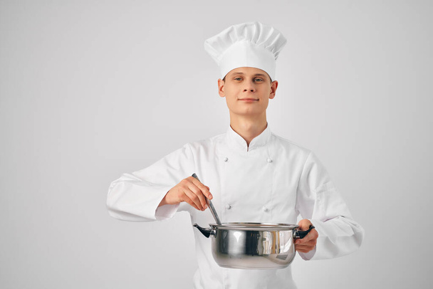 ein Mann in einer Koch-Uniform mit einer Pfanne in den Händen bei der Zubereitung von Essen Restaurant - Foto, Bild