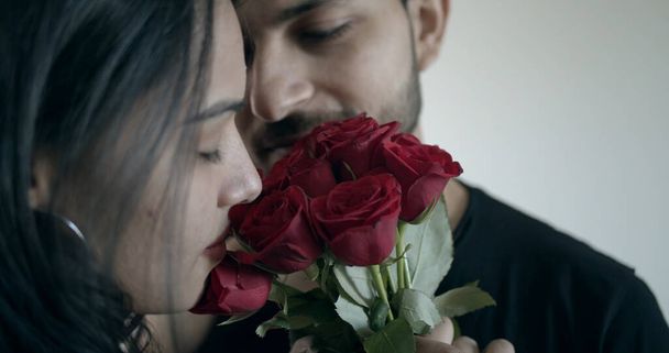 Lähikuva nuoresta intialaisesta pariskunnasta, jolla on punaisia ruusuja. - Valokuva, kuva