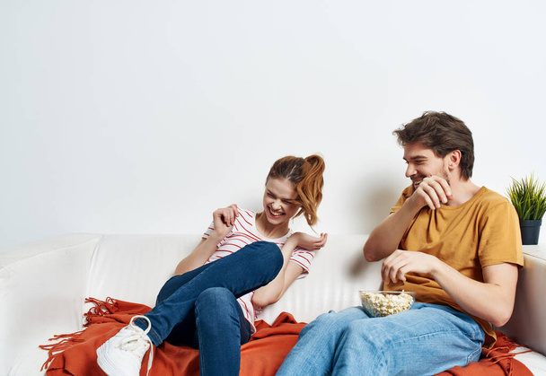 hauska mies ja nainen kotona sohvalla hauskaa levätä popcorn - Valokuva, kuva