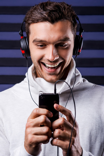 Man in headphones holding MP3 Player - Foto, Imagen