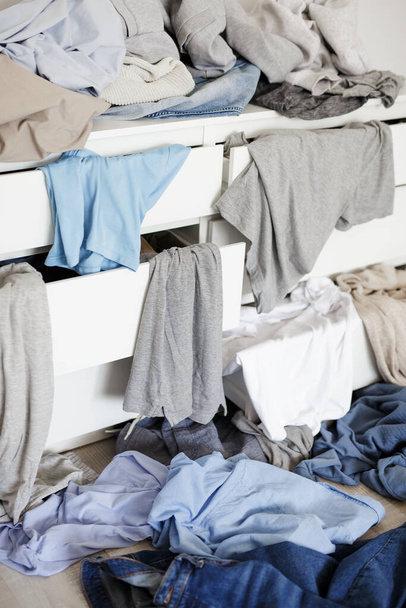housework and routine concept - close up of dirty laundry in the chest of drawers - Foto, Imagen