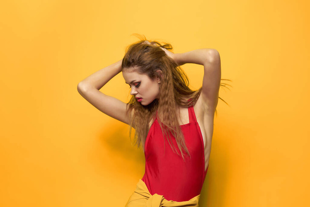 красива жінка в червоній футболці косметика прикраса моди жовтий фон
 - Фото, зображення