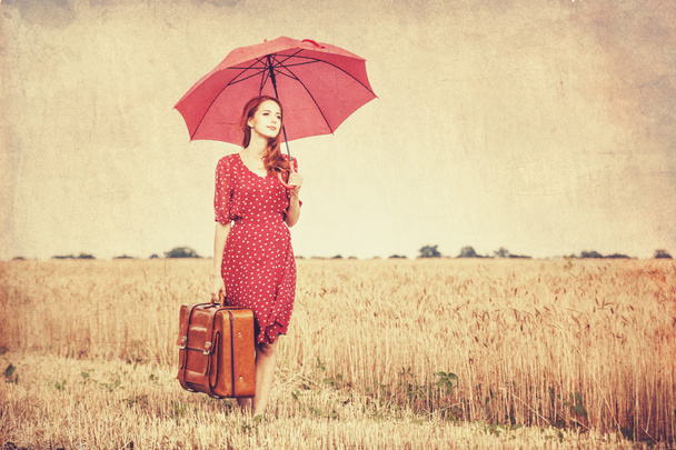 κοκκινομάλλα κοπέλα με ομπρέλα και βαλίτσα σε εξωτερικούς χώρους - Φωτογραφία, εικόνα