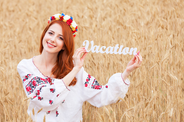 Punapää tyttö kansallisen ukrainan vaatteita puinen sana Vaca
 - Valokuva, kuva