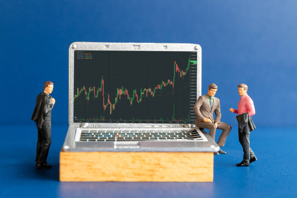 Miniature people, Business people consulting with professional financial advisors and tablets featuring stock tickers, Stock market or forex trading graph in graphic concept - Photo, image
