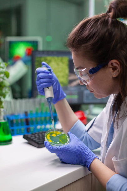 Chimiste femme prenant de l'ADN liquide de tube à essai avec micropipette - Photo, image