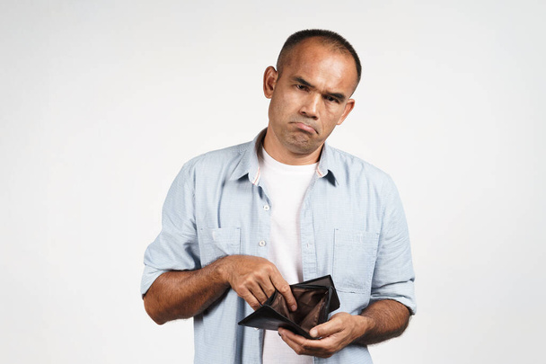 Rozrušený dospělý muž, který se dívá do prázdné peněženky na bílém pozadí. finanční krize, bankrot, žádné peníze, špatná ekonomika Koncept - Fotografie, Obrázek