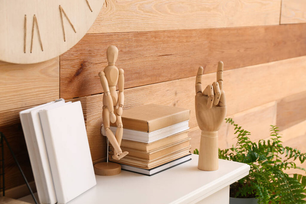 Drewniana ręka, manekin i książki o kominku - Zdjęcie, obraz