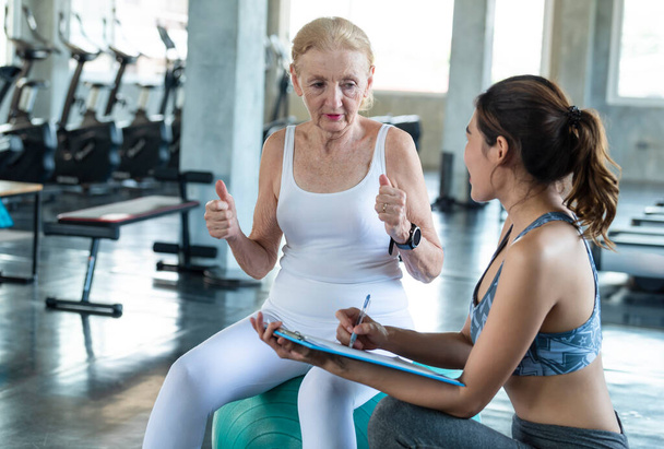 Тренер с упражнениями для пожилых женщин в спортзале. здоровый образ жизни пожилых людей и концепция тренировок - Фото, изображение