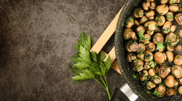 fried mushrooms and parsley in a pan - Foto, imagen