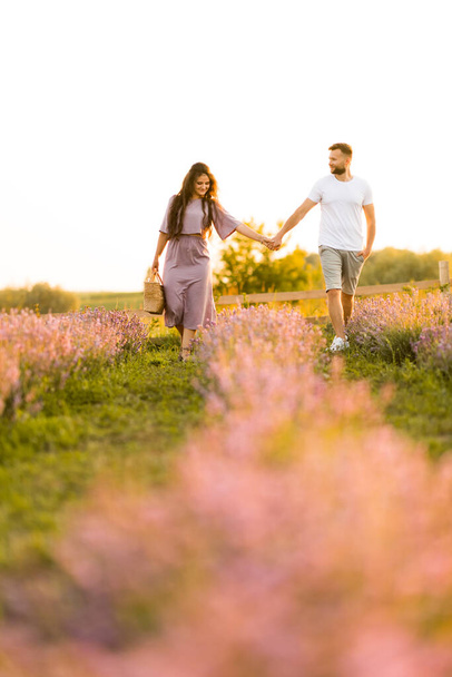 young couple in love relaxing in the field at sunset  - Foto, immagini