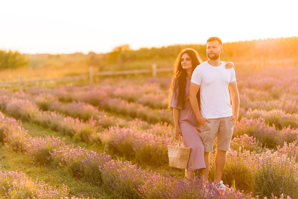 young couple in love relaxing in the field at sunset  - Foto, Imagem