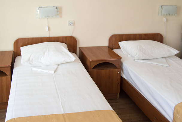 Chambre d'hôtel avec deux lits simples vides et tables de chevet, le concept de l'hôtellerie. - Photo, image