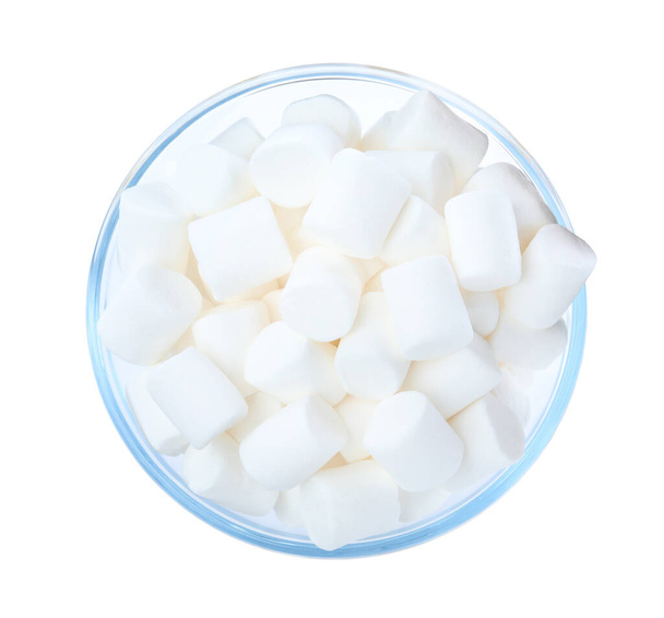 Delicious puffy marshmallows in glass bowl on white background, top view - Фото, изображение