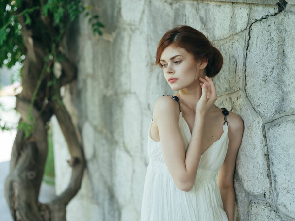 pretty woman in white dress posing in nature near a tree Greece - Zdjęcie, obraz
