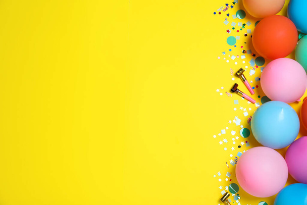 Flat lay composition with balloons and confetti on yellow background, space for text. Birthday decor - Valokuva, kuva
