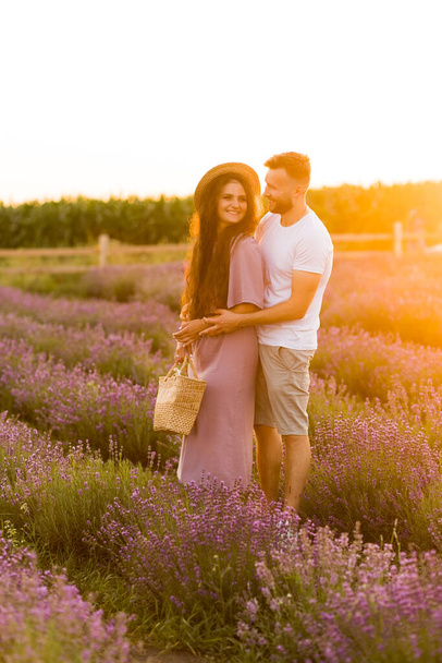 young couple in love relaxing in the field at sunset  - Foto, afbeelding