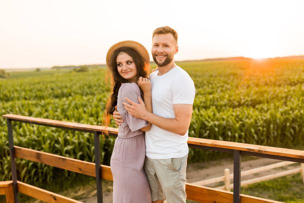 young couple in love relaxing in the field at sunset  - Fotografie, Obrázek