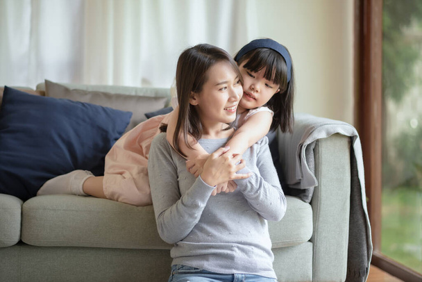 Asian mother make love with warm hug her cute daughter at home - Fotoğraf, Görsel
