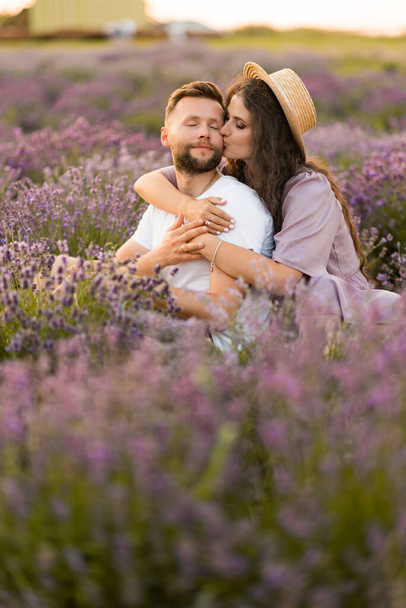 young couple in love relaxing in the field at sunset  - Fotografie, Obrázek