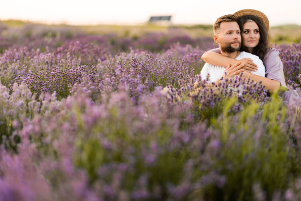 young couple in love relaxing in the field at sunset  - Valokuva, kuva