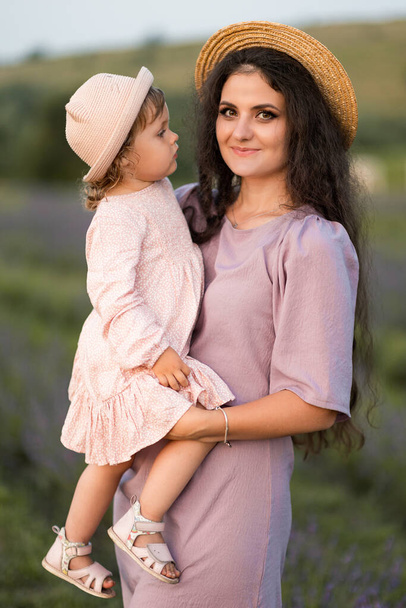 young beautiful mother and daughter in a lavender field  - Photo, image