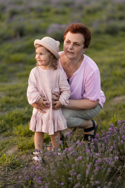 jong moeder en dochter in een lavendelveld - Foto, afbeelding