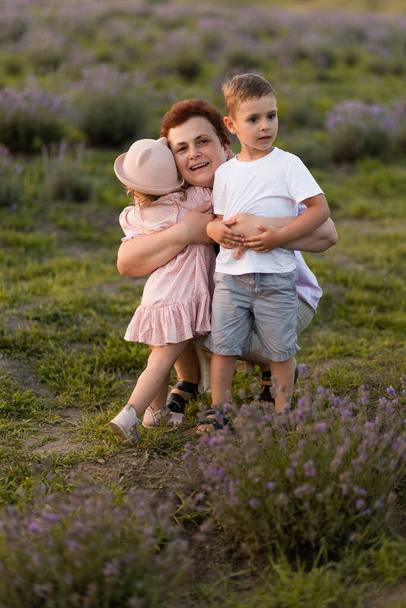 glückliche Großmutter mit Kindern auf dem Feld - Foto, Bild