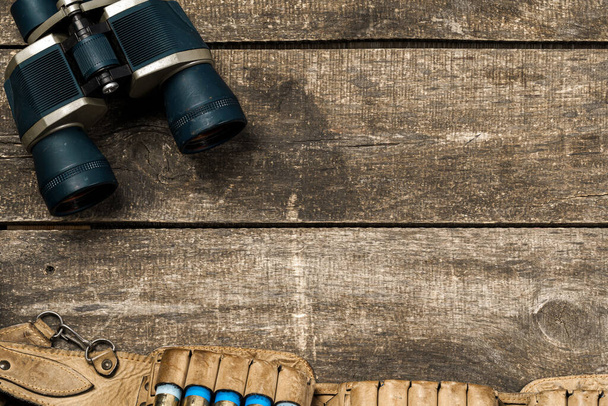 Hunting equipment binoculars on wooden background close up - Foto, imagen