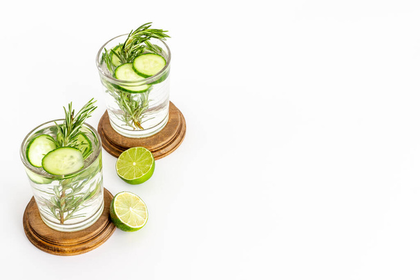 Cold soda drink with pieces of cucumber lime and herbs - Фото, изображение