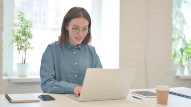 Succesvolle jonge vrouw viert feest op laptop op het werk  - Video